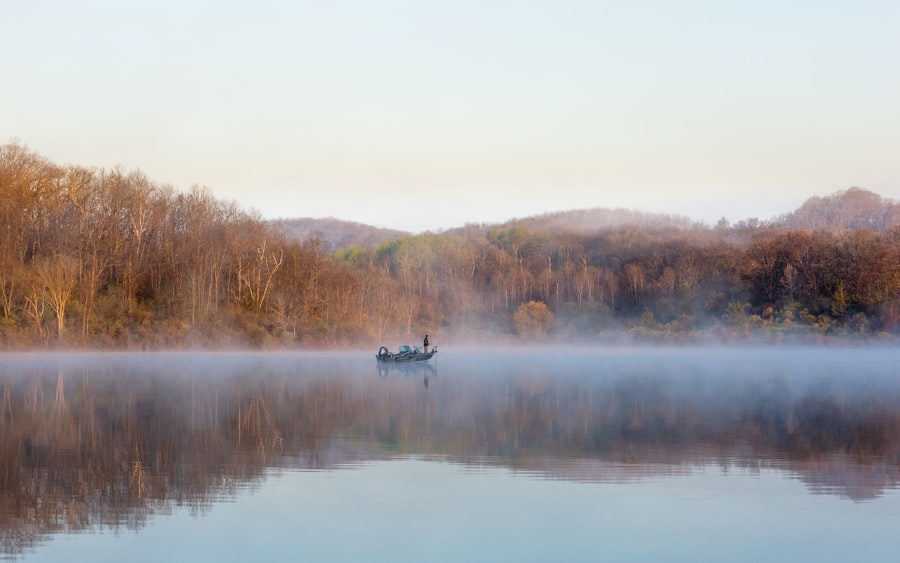 A fisherman on a misty Northwoods lake at sunrise